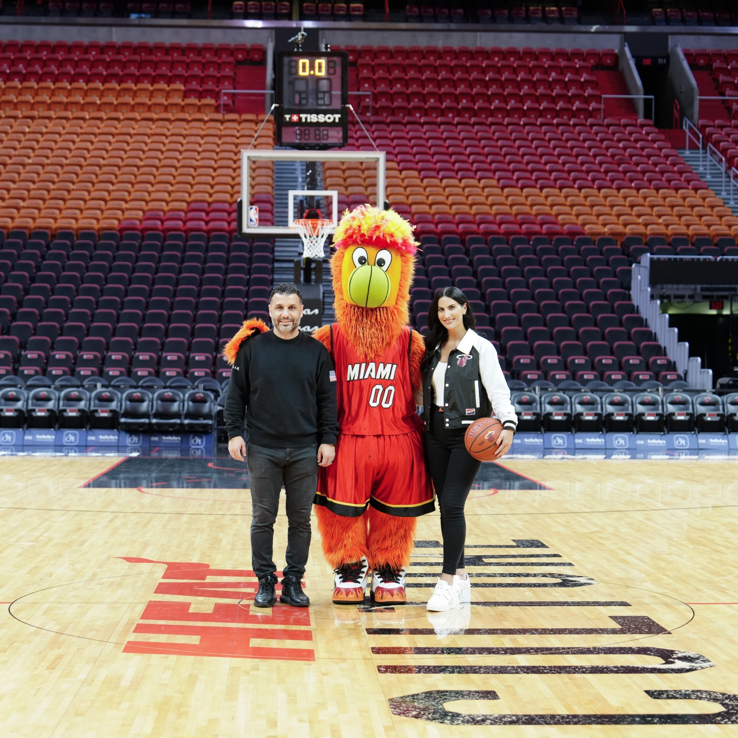 Photo of Burnie (Miami Heat Mascot), Emre Basman, Alena Capra, at the Kaseya Center basketball court