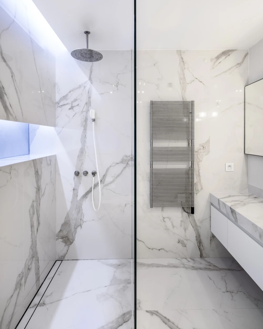 Modern French villa interior featuring Laminam Calacatta Oro Venato Italian porcelain flooring and wall cladding; elegant white surface with striking gold and grey veining, enhancing the contemporary design.